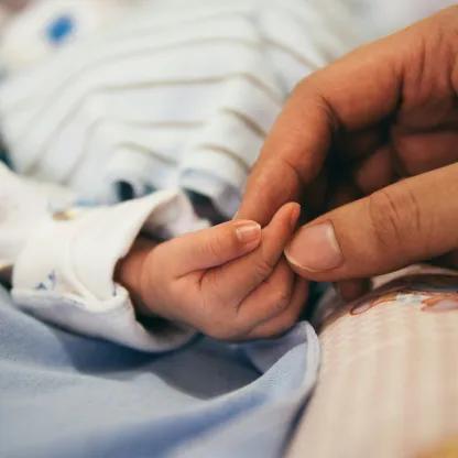 Adult holding hand of a baby